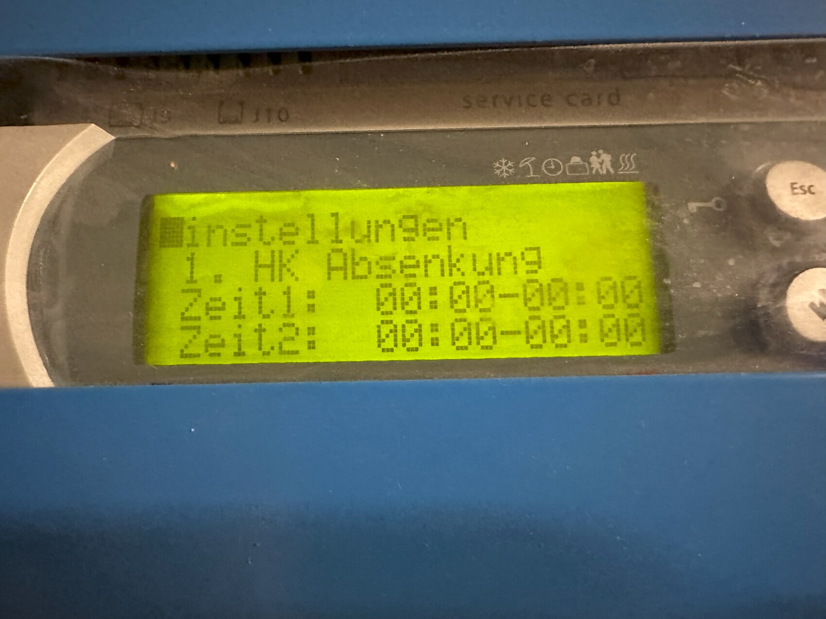 Nahaufnahme eines Maschinen-Displays mit grünem LCD, Text Installationen, Zeit1/2, in blauem Gehäuse.