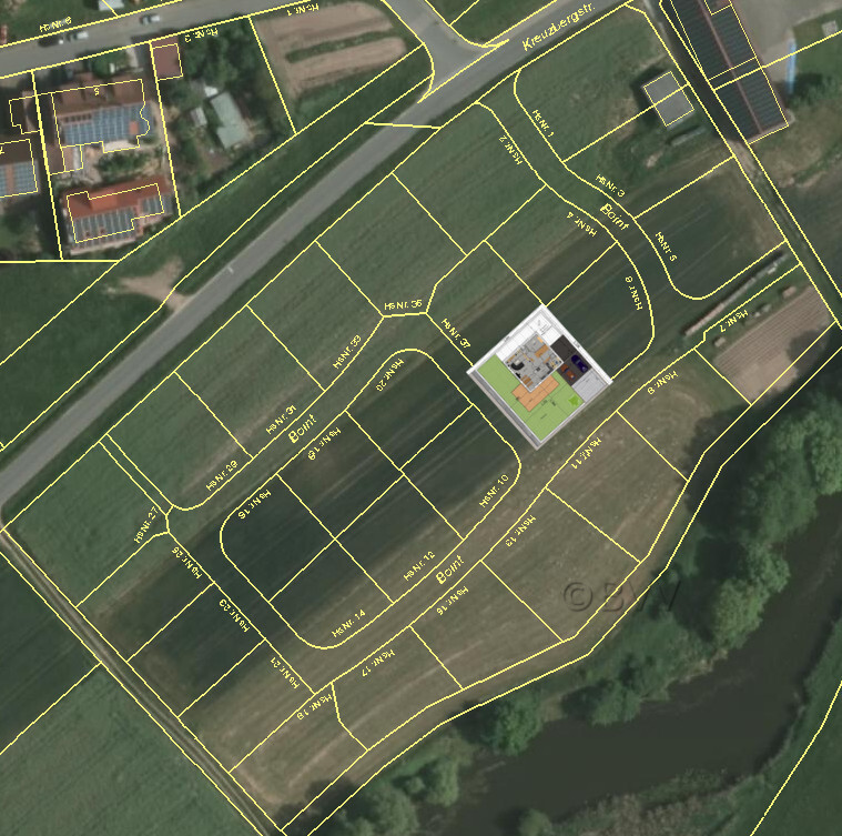 Satellitenbild einer Parzellennetzkarte mit gelben Grundstücksgrenzen, Straßen und einem Gebäude.