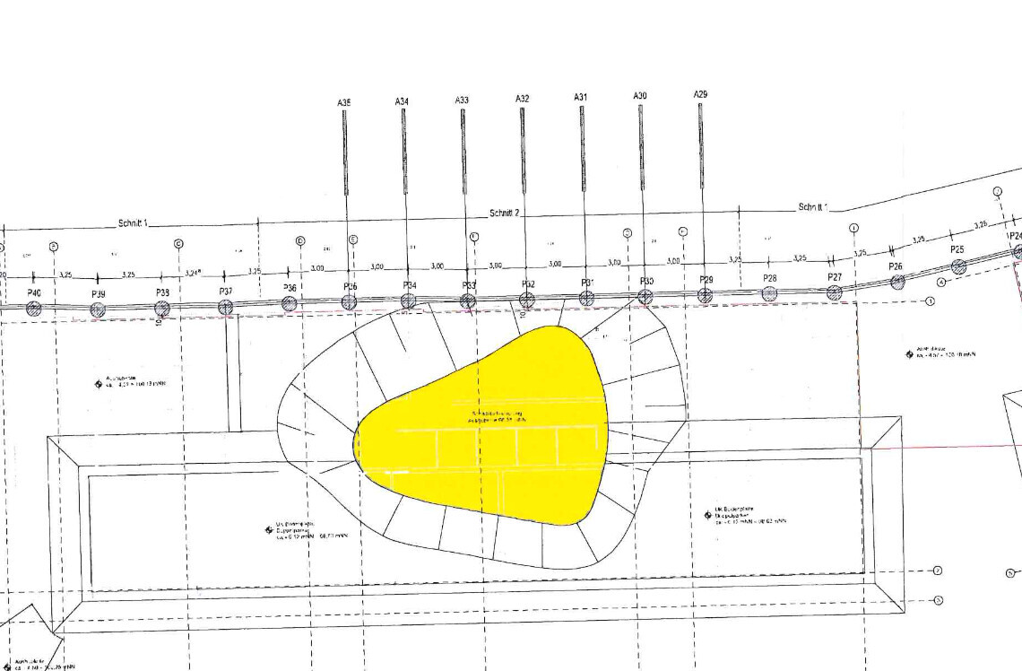 Technische Zeichnung eines Bauplans mit gelb markiertem Innenbereich in ovalem Umriss.