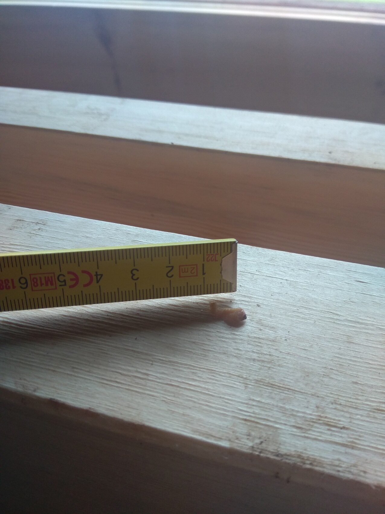 Nahaufnahme eines gelben Messbands auf einer Holzfensterbank mit Holzoberfläche