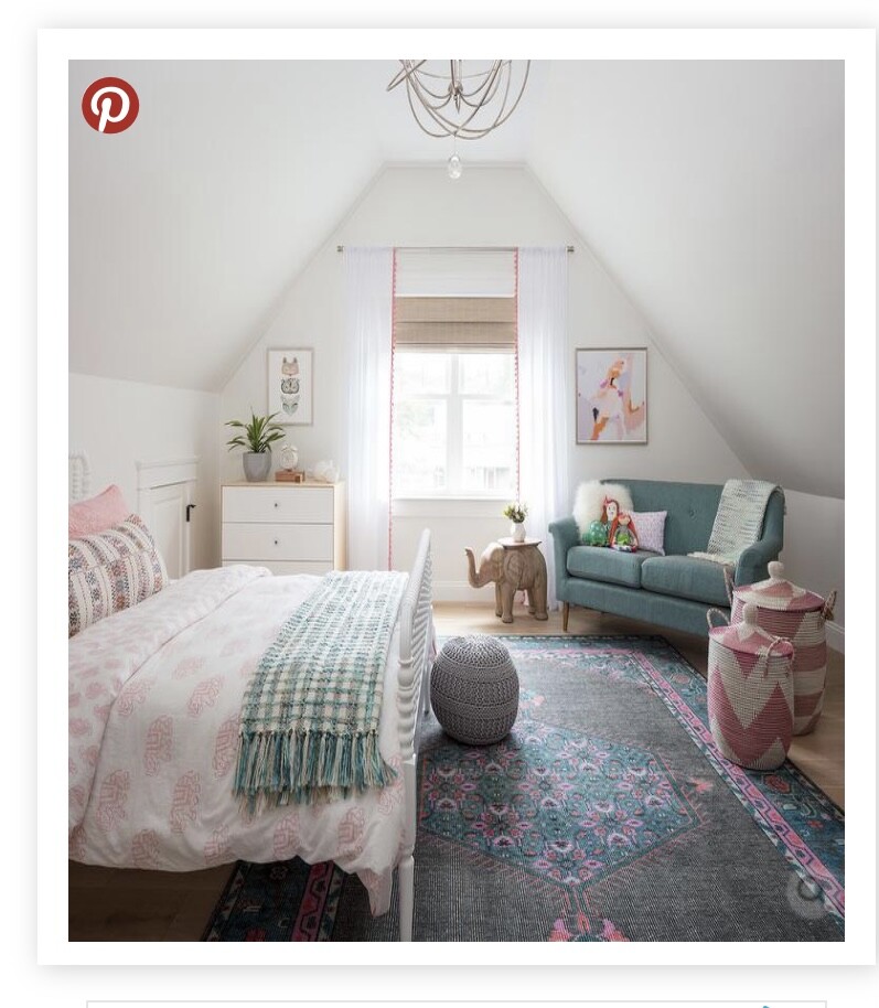 Helles Dachboden-Schlafzimmer mit Bett links, Sofa rechts und Fenster in der Mitte.