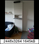 Kleines Schlafzimmer mit Bett, Kleiderschrank und offenen Regalen