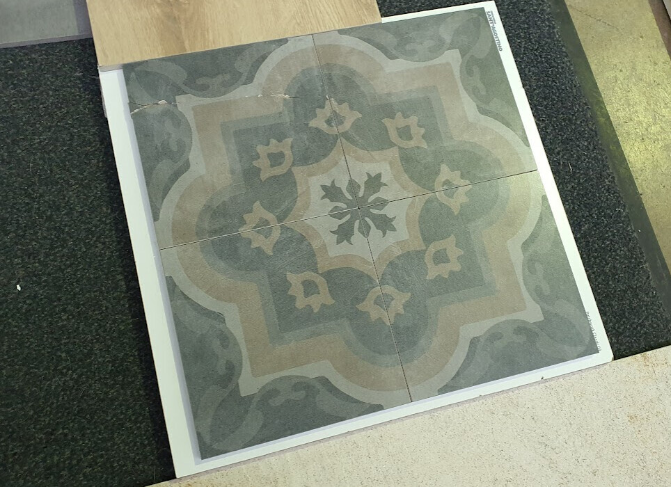 Bodenfliesen-Panel mit zentralem, blumenförmigem Muster in Grau-Beige.