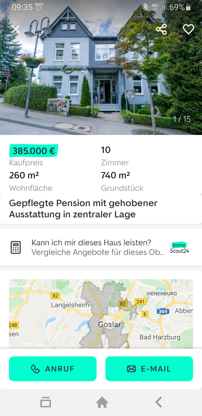 Zweistöckiges, blaues Pension-Haus mit Eingang, Schild Pension Evergreen und grünem Garten.