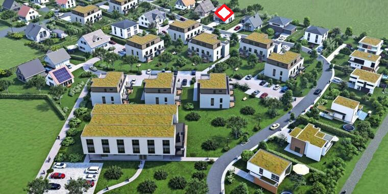 Luftbild eines Wohngebiets mit vielen weißen Häusern, gelben Dächern, Grünflächen und Straßen.