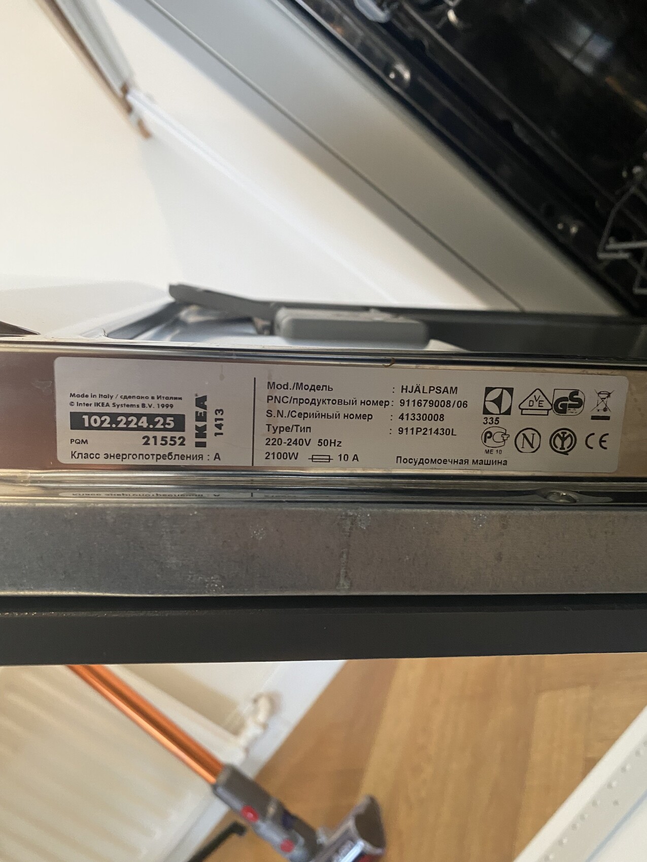 Offene Spülmaschine mit sichtbarem Typenschild und technischen Daten am Rahmen.