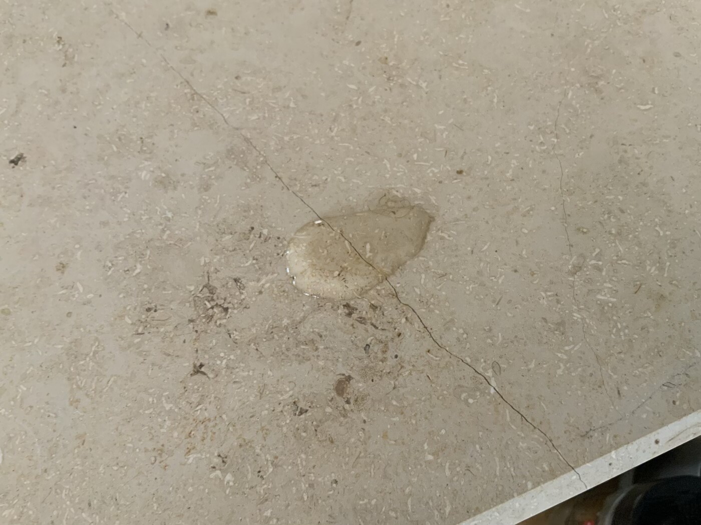 Betonboden mit feinem Riss und einem runden hellen Fleck