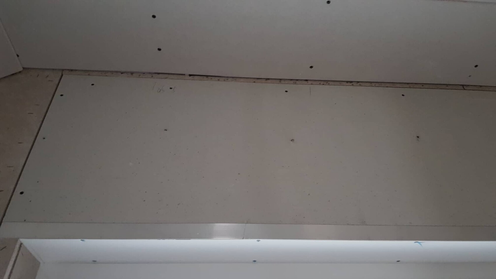 Unbearbeitete Gipskartonplatten an Innenausbau-Baustelle mit Schrauben
