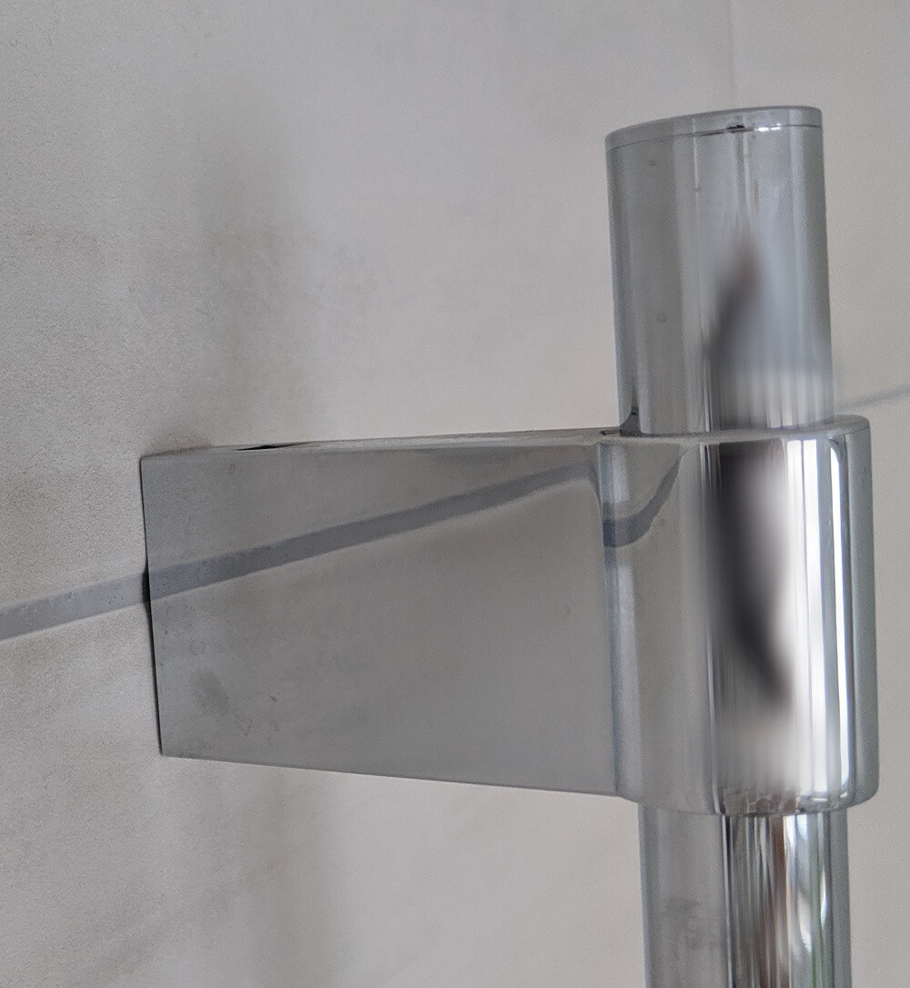 Chromierte Metallkonstruktion in T-Form: senkrechter Zylinder über einer flachen, waagerechten Stange.