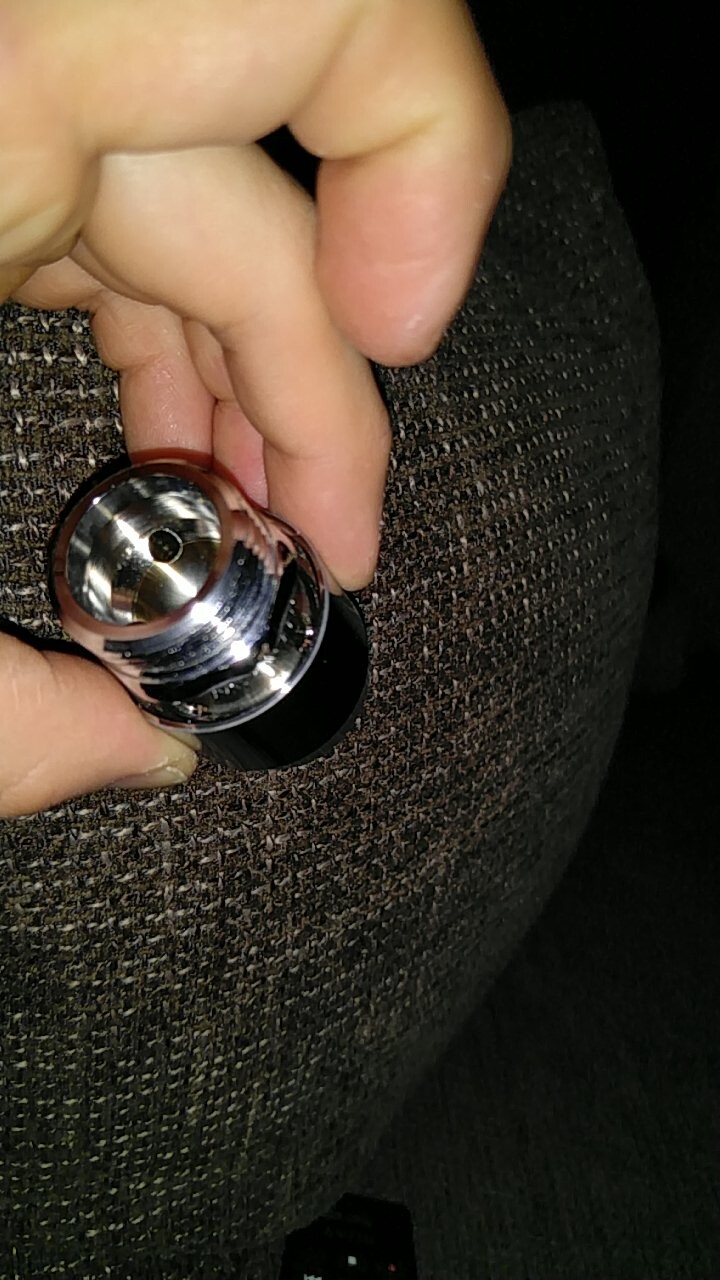 Person hält glänzenden Schlosszylinder in der Hand vor dunklem Stoff