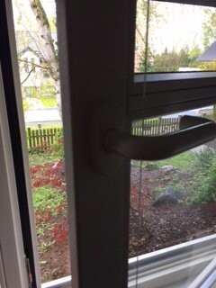 Türgriff an Glas-Tür mit Blick nach draußen auf Garten