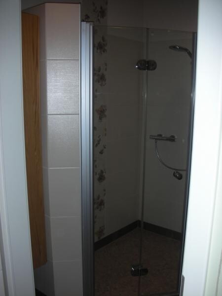 Kleines Badezimmer mit Glas-Duschkabine in der Ecke
