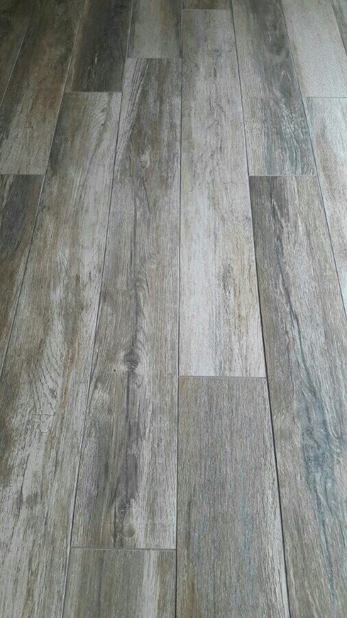 Grauer Holzboden aus langen Dielen mit sichtbarer Maserung.