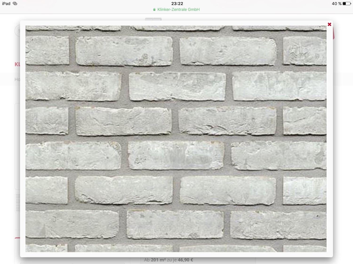 Grau-weiße Ziegelsteinwand mit sichtbarem Fugenmörtel.