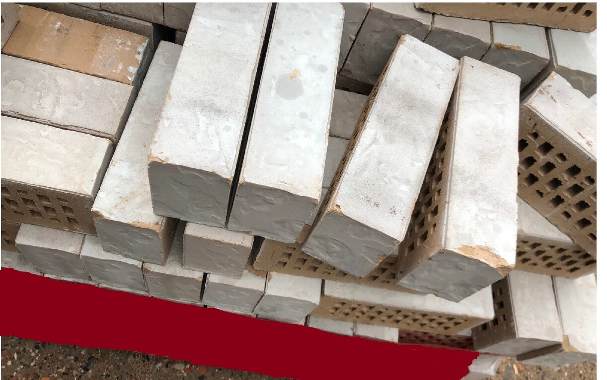 Stapel grauer Betonhohlblocksteine auf einer Baustelle.