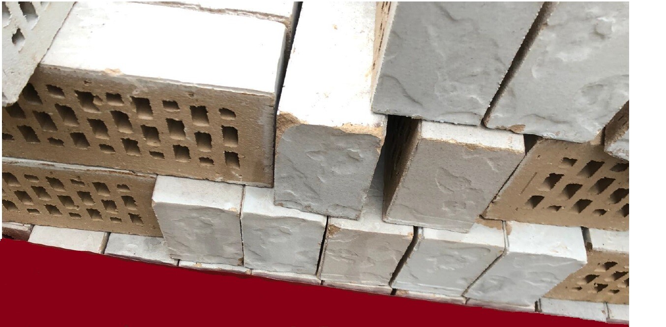 Stapel grauer Beton- und Hohlblocksteine auf Paletten