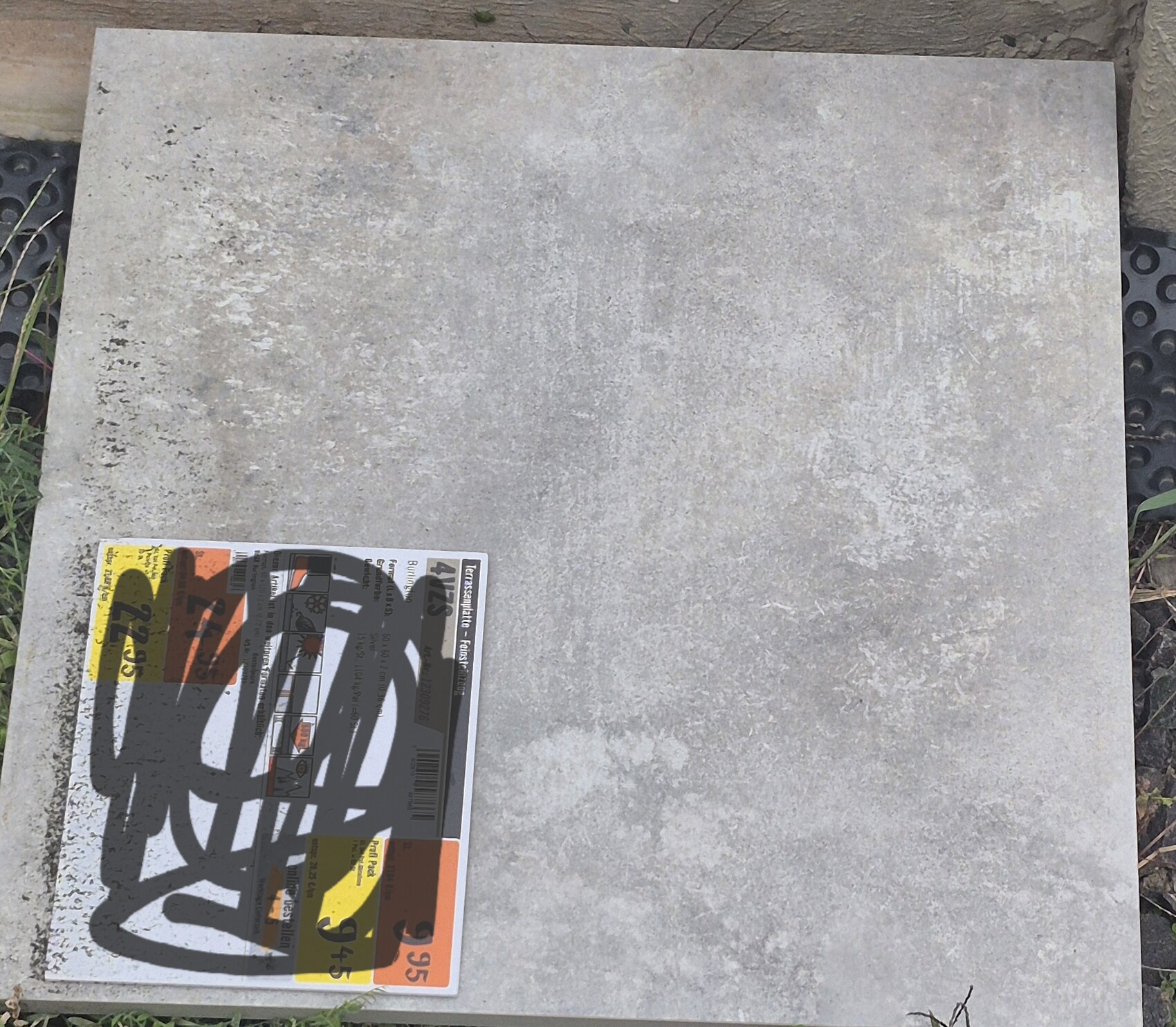 Große graue Betonplatte mit kleinem Etikett in der Ecke