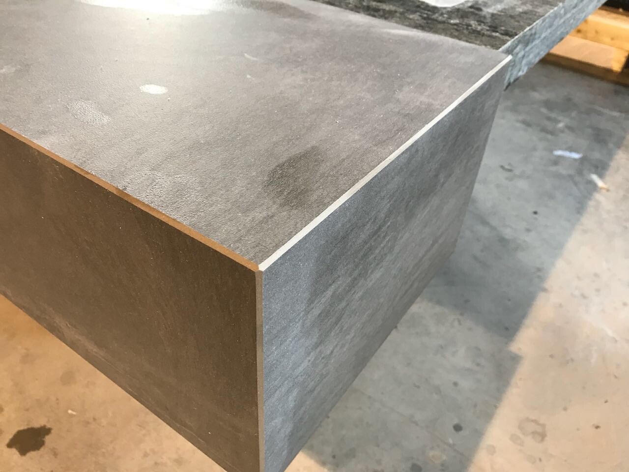 Nahaufnahme einer grauen Laminatplatte mit Kante in der Werkstatt