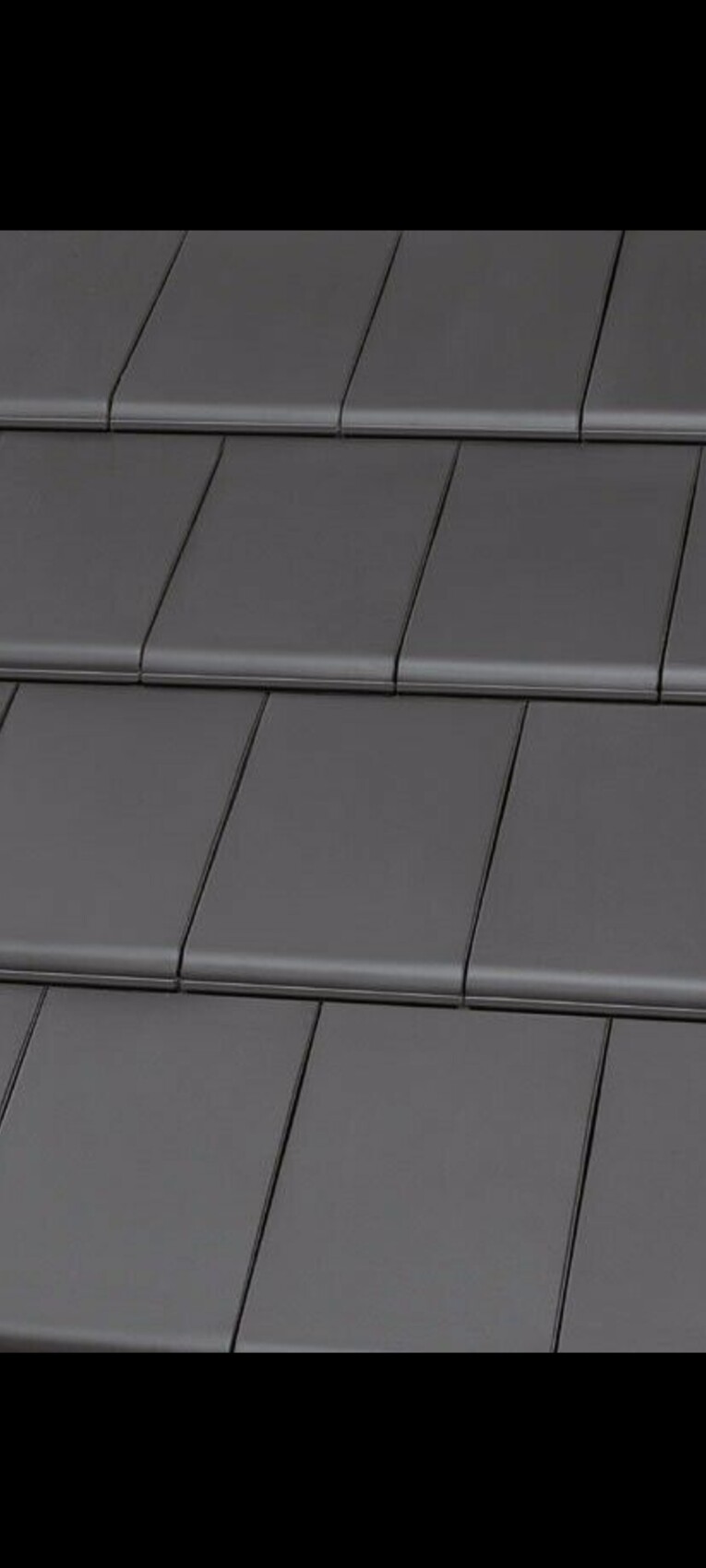 Nahaufnahme grauer Metall-Dachplatten, die sich überlappen.