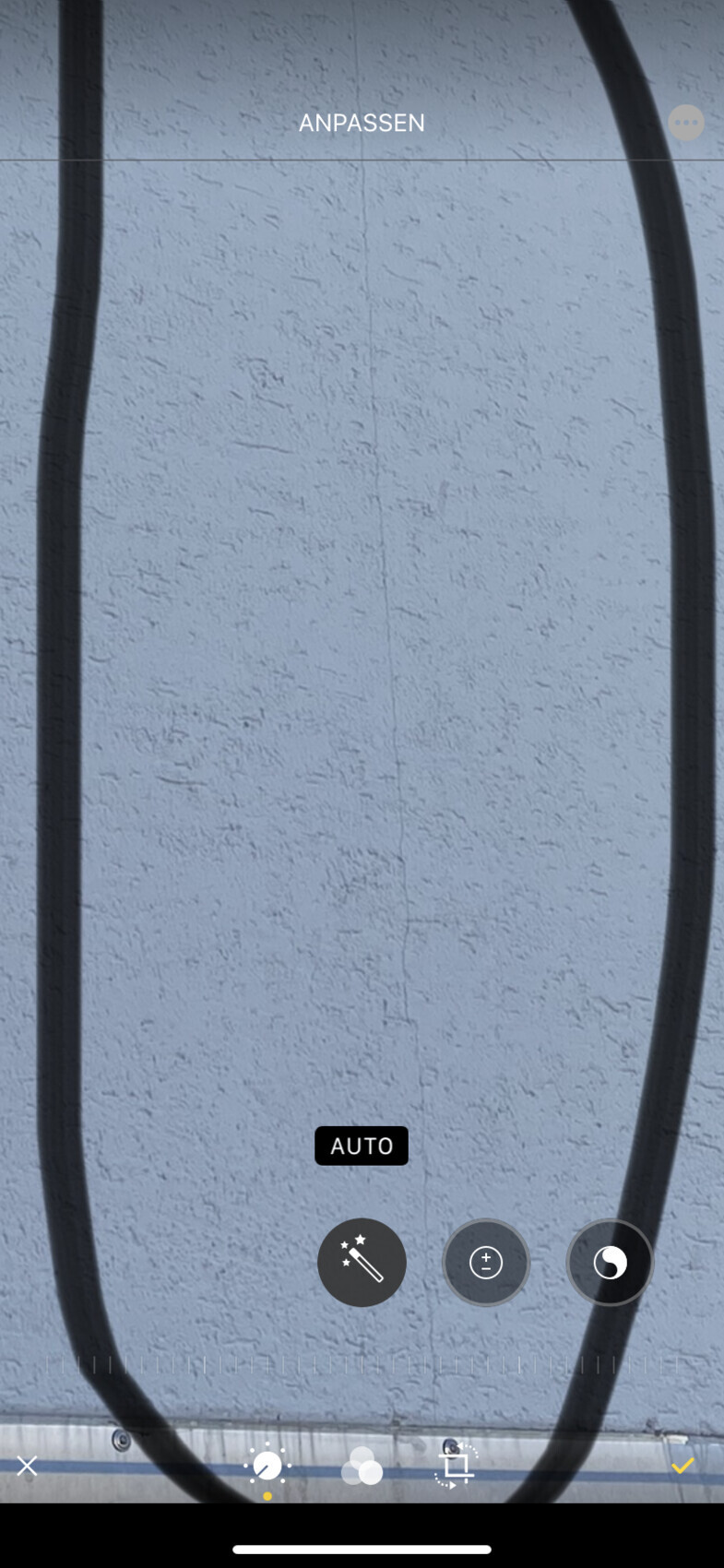 Blaue, grob texturierte Wand mit zwei großen schwarzen Kabeln, die ein Oval bilden.