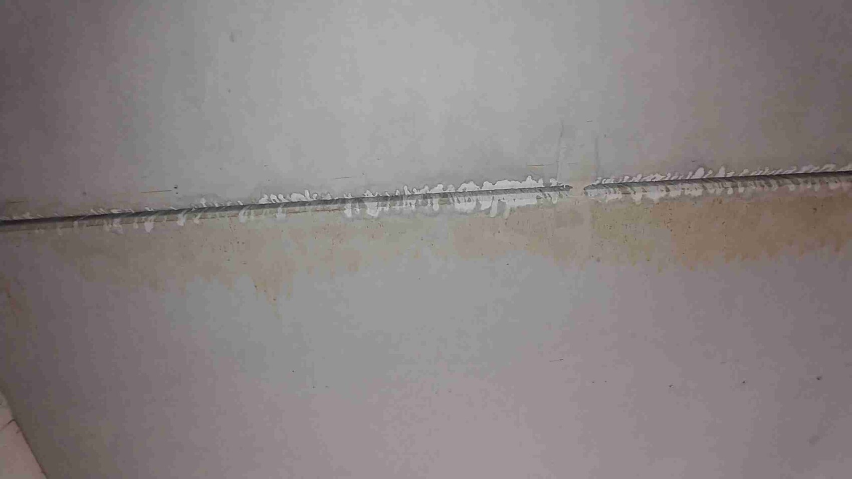 Horizontale Betonwandfuge mit weißem Ausbesserungsmaterial