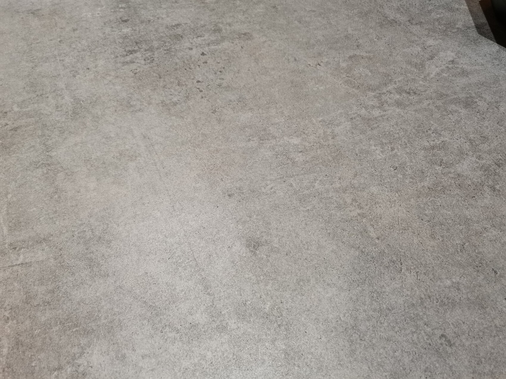 Grau verlegter Betonboden mit unregelmäßiger Textur.