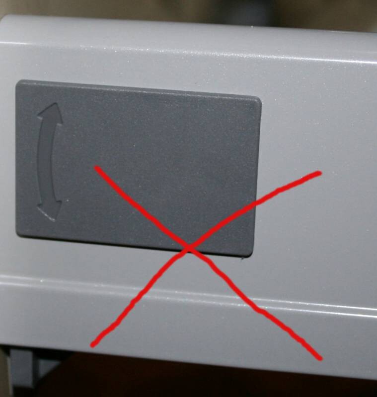 Nahaufnahme eines grauen Bedienfelds mit Schiebeschalter und rotem X.