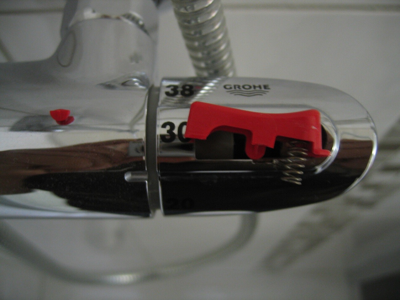 Nahaufnahme einer Grohe-Chromarmatur mit rotem Hebel und sichtbarer Skalenmarkierung.