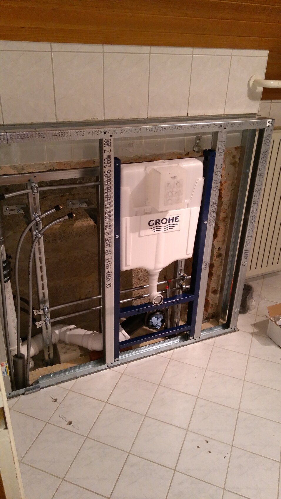 Grohe Unterputz-Spülkasten im Installationsrahmen, Badezimmerwand mit Rohren.