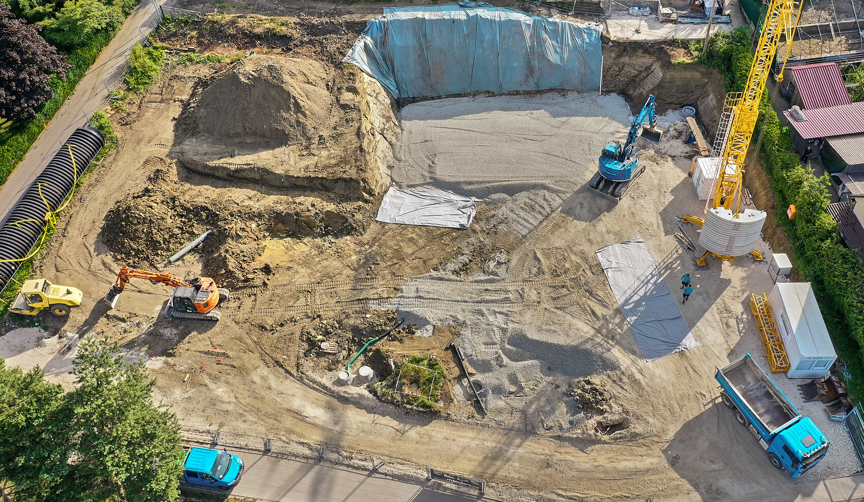 Vogelperspektive: Baustelle mit großer Baugrube, Bagger, Kran, Schotter, LKW