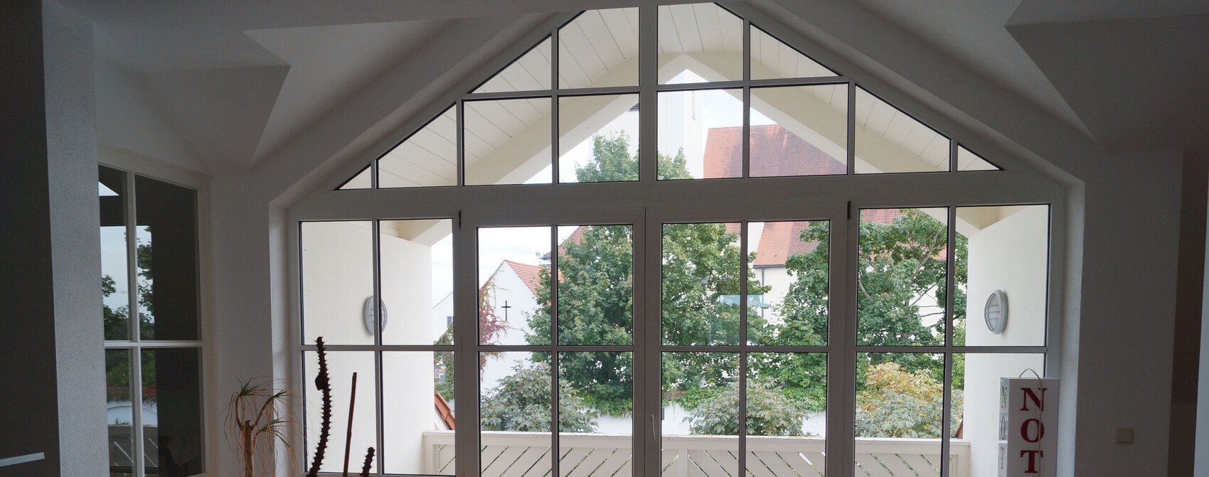 Große Glasfront im Wohnzimmer mit vielen Fenstern und Tür zur Terrasse