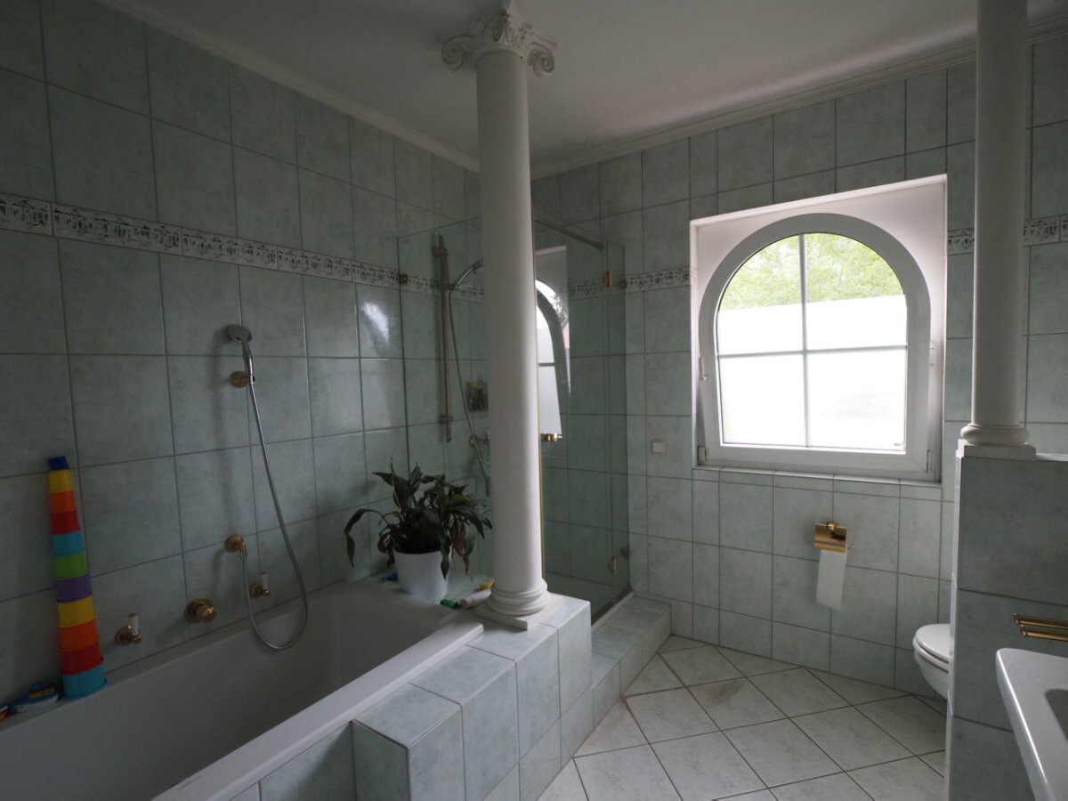 grosses-badezimmer-mit-badewanne-dusche-und-halbrundem-fenster.jpg