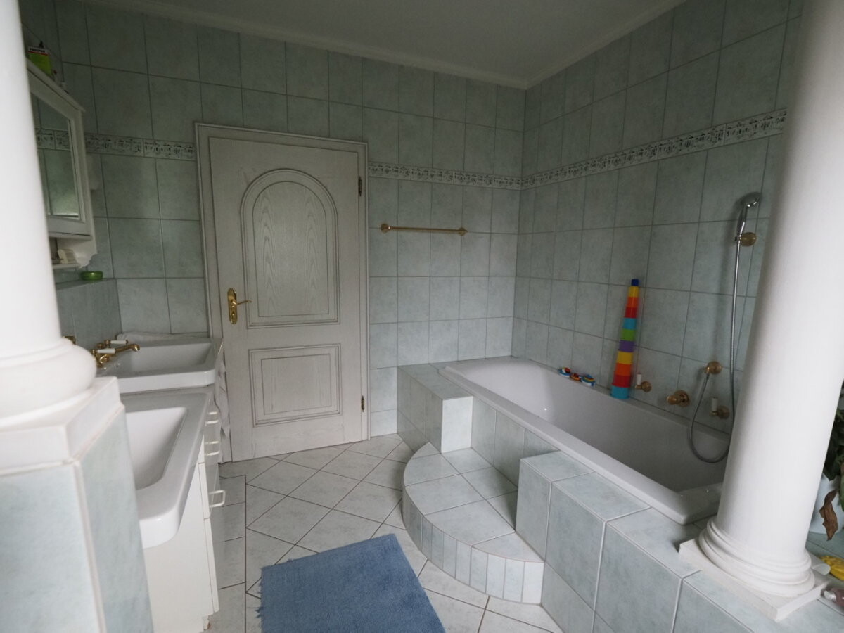 grosses-badezimmer-mit-badewanne-und-fliesen.jpg