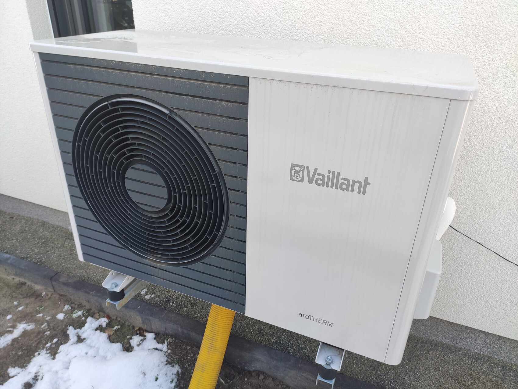 Außen-Wärmepumpeneinheit von Vaillant mit großem Lüfter an der Hauswand.