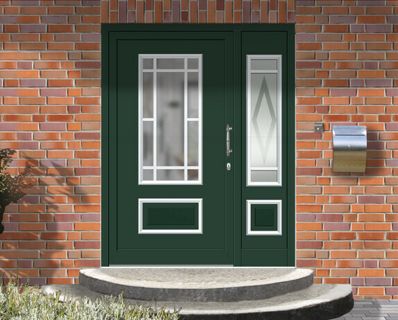 Grüne Haustür mit zwei Glasfenstern vor Backsteinfassade; rechts ein Briefkasten.