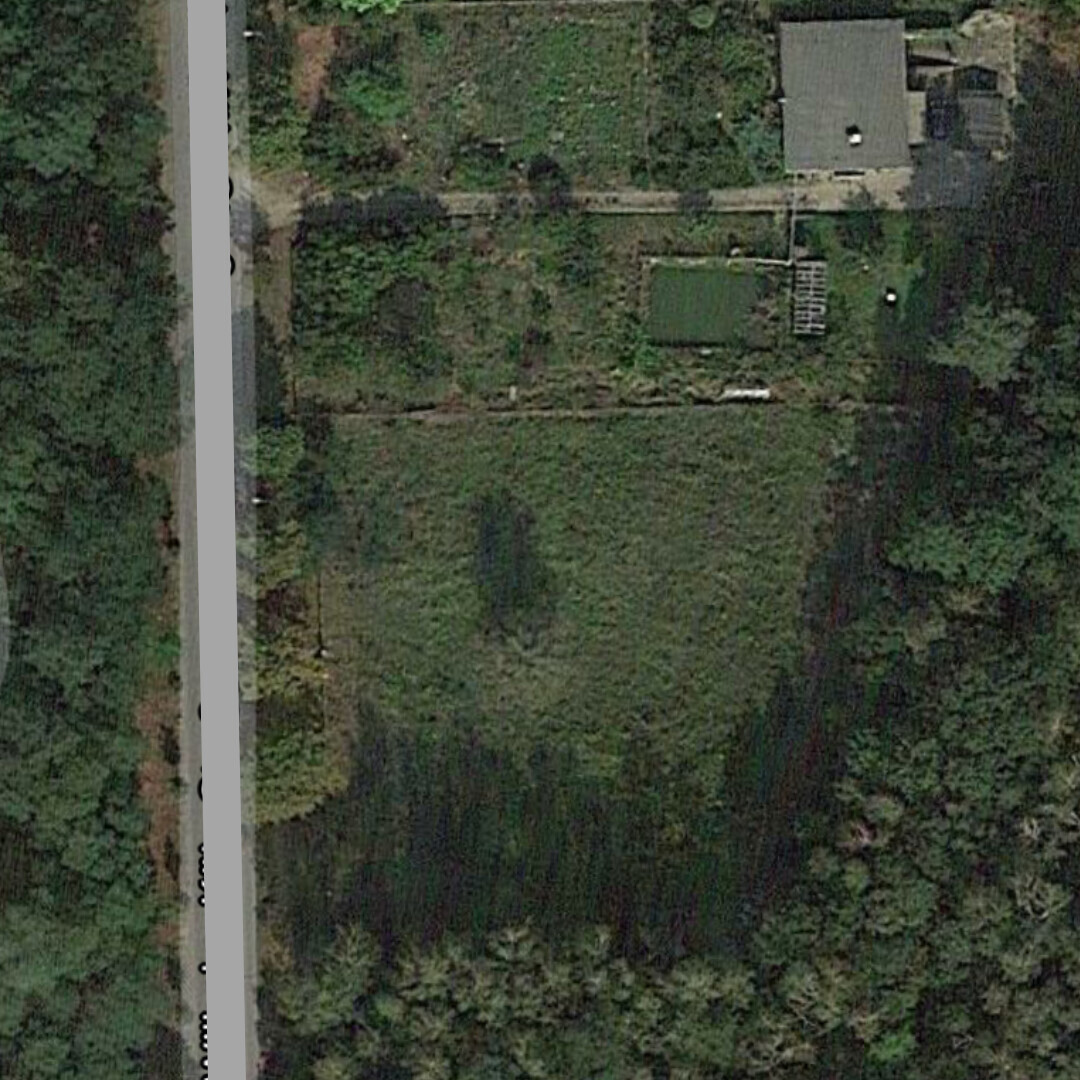 Luftaufnahme eines Gartens mit Rasen, Bäumen und kleinem Haus oben rechts