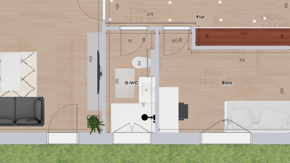 Grundriss: Wohn- und Bürobereich mit Sofa links, G-WC Mitte, Schreibtisch rechts, Flur oben.