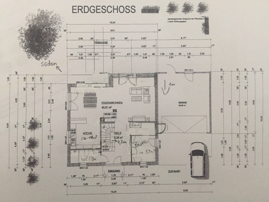 Grundriss des Erdgeschosses mit Küche, Essbereich, Wohnzimmer, Garage und Terrasse.