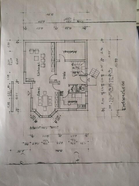 Grundrisszeichnung des Erdgeschosses mit Wohnzimmer, Essbereich, Küche und Flur.