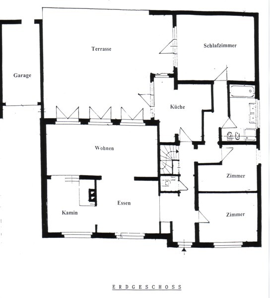 Grundriss des Erdgeschosses mit Terrasse, Wohnzimmer, Küche, Schlafzimmern, Flur und Garage.