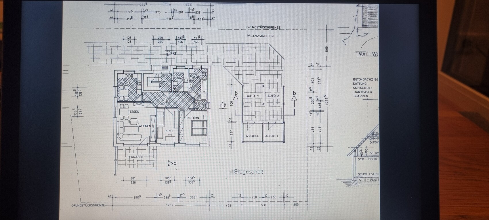 Erdgeschoss-Grundriss: Wohnen, Essen, Küche, Eltern- und Kinderzimmer, Terrasse, Abstellräume, Garage.