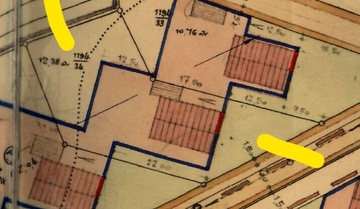 Grundriss eines Grundstücks mit blauer Umrandung, roten Schraffuren und Maßen