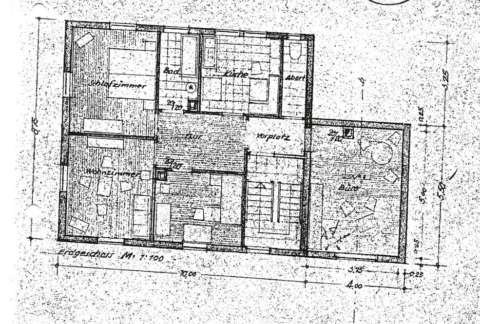 Grundriss eines Hauses mit Wohnzimmer, Küche, Bad, Flur und Treppenhaus.