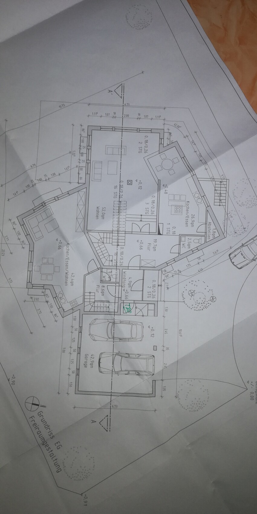 Grundriss eines Einfamilienhauses mit Garage, Pkw-Stellplätzen und Garten.