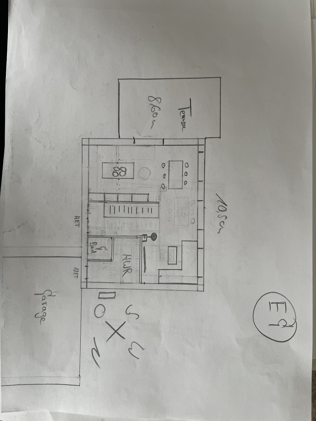 Grundriss eines Hauses: Küche mit Insel, Esstisch, Terrasse und Garage.