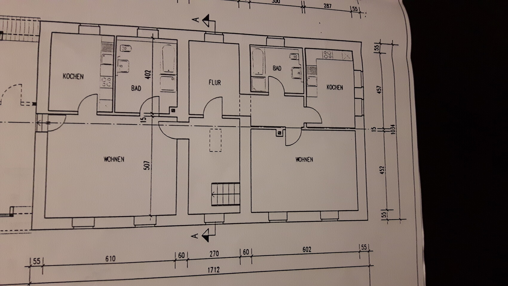 Grundriss: zwei Wohnungen mit Küche, Bad, Flur und Wohnzimmer; Maßlinien sichtbar