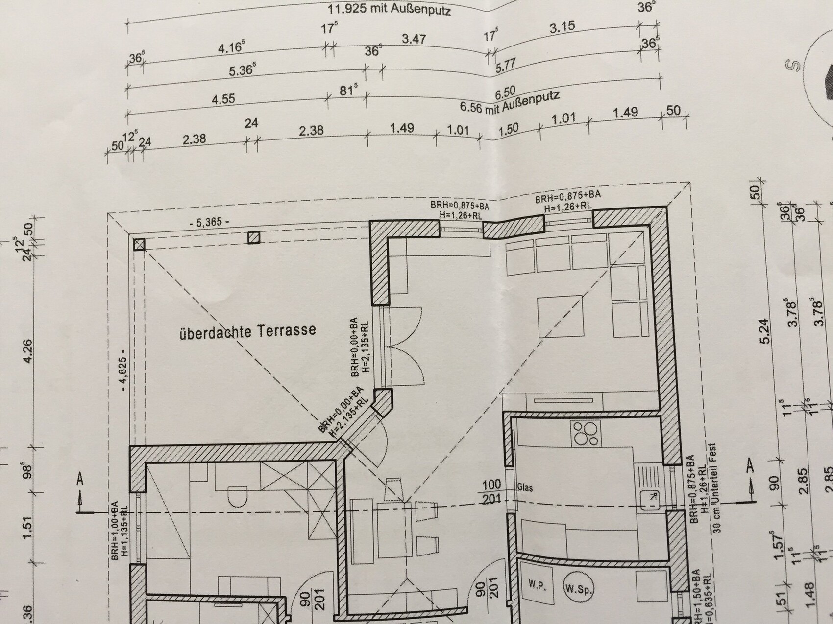 Architekten-Grundriss eines Wohnhauses mit überdachter Terrasse, Küche und Wohnzimmer.