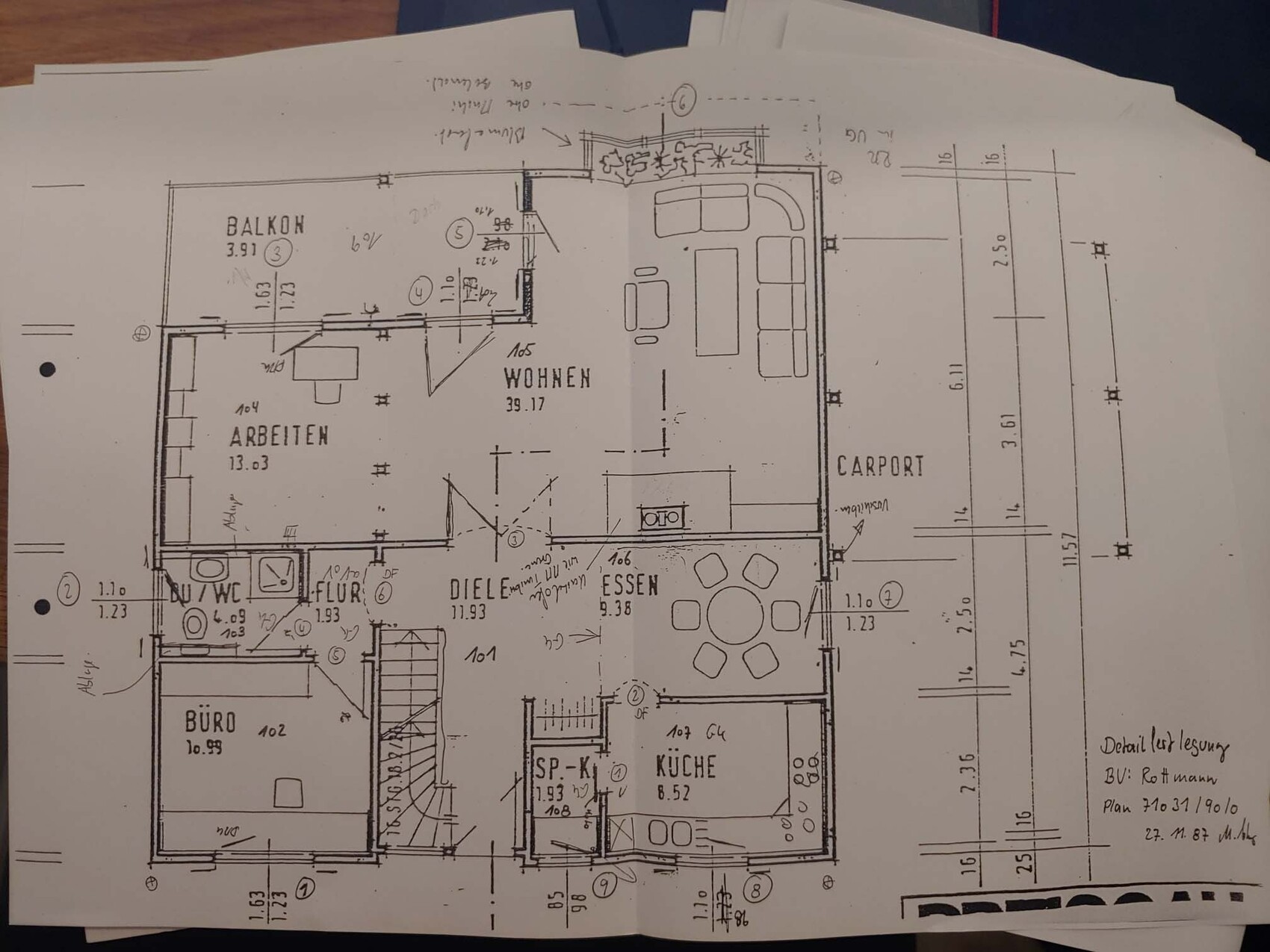 Grundriss eines Wohnhauses: Wohnzimmer, Arbeitsbereich, Küche, Essbereich, Balkon und Carport.