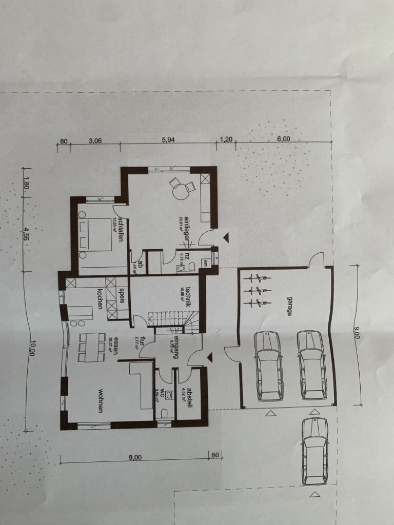 Grundriss eines Hauses mit Wohnzimmer, Küche, Essbereich, Schlafzimmer, Bad, Abstellraum und Garage.