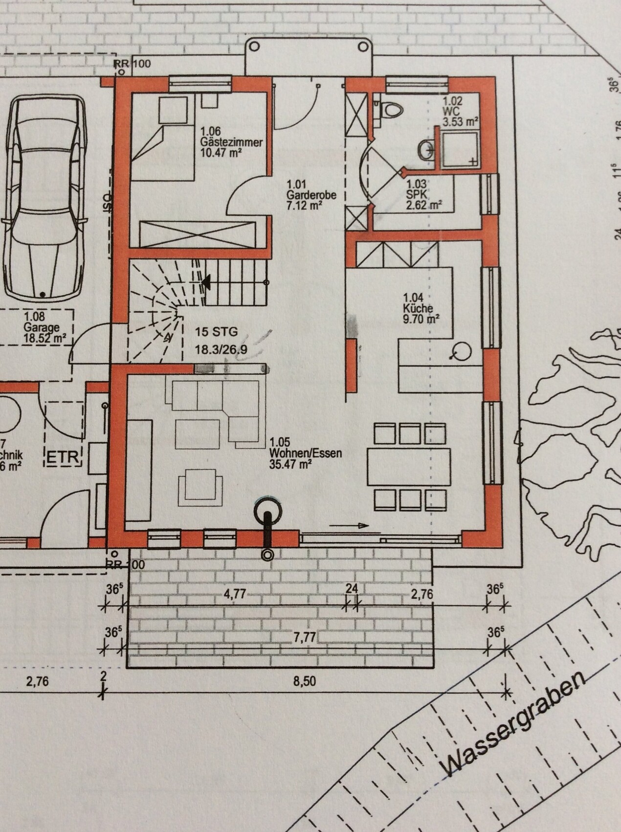 Grundrissplan eines Hauses mit Küche, Wohnzimmer, Bad, Garage und Terrasse